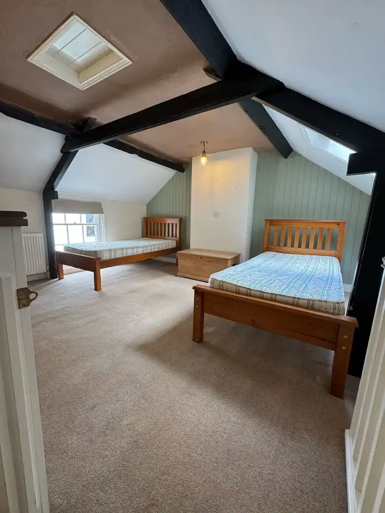 Attic bedroom with exposed beams and a rooflight