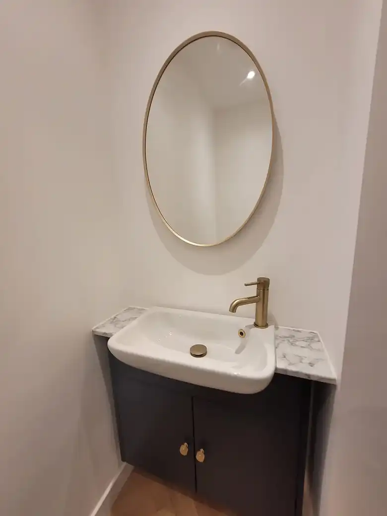 Brass taps and oval mirror