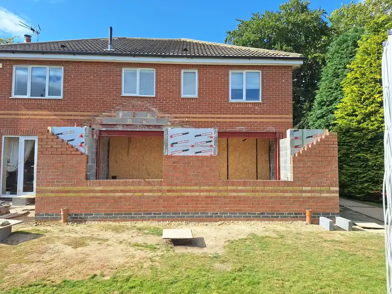 Brick outer skin rising across the back of the house