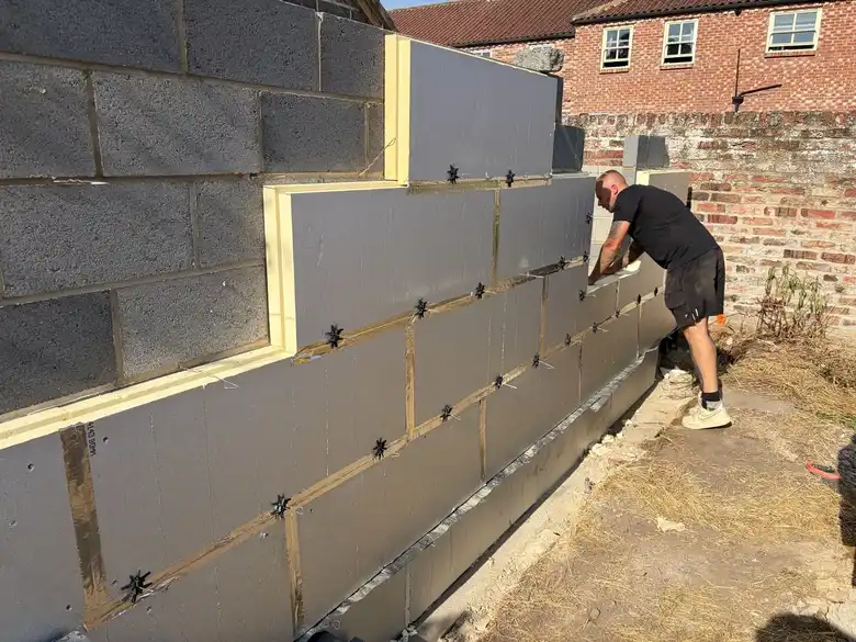 Cavity insulation going on the blockwork
