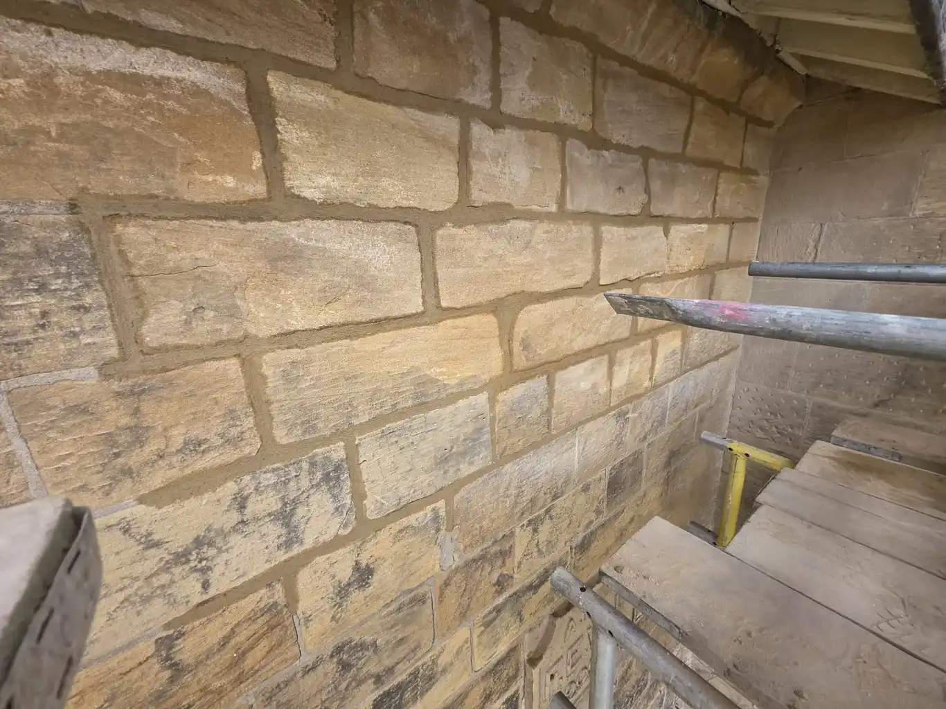 Coursed sandstone wall repointed in lime