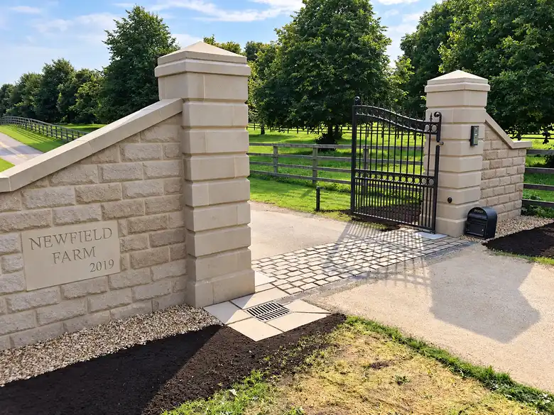 Dressed stone gate piers and wall