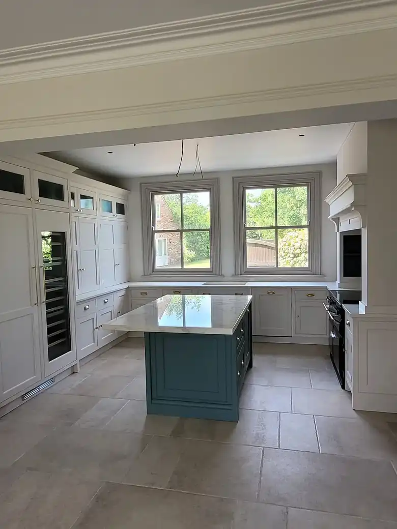Kitchen with an island under a pair of sash windows