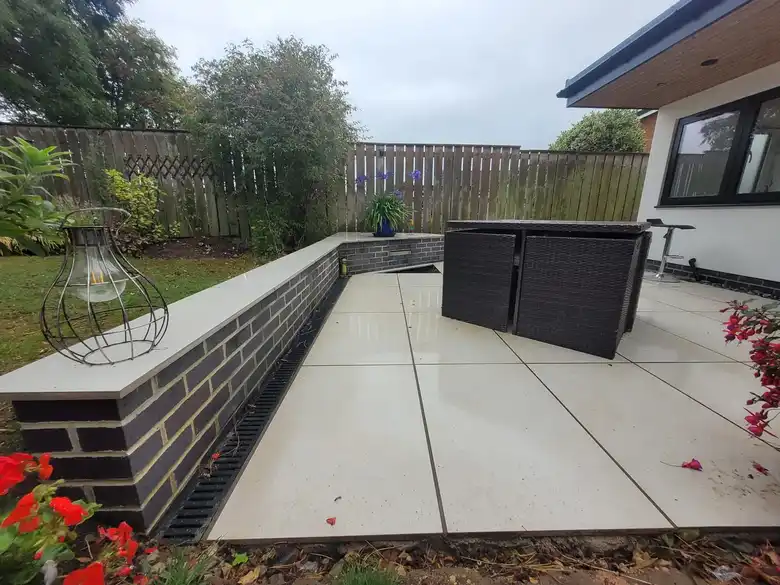 Porcelain patio beside a rendered extension
