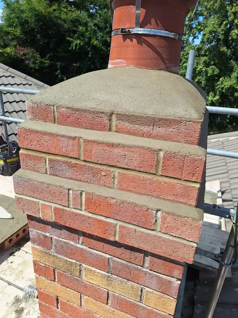 Rebuilt brick chimney stack on a tiled roof