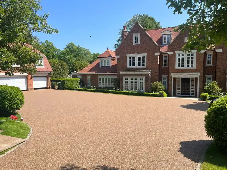 Resin bound driveway in front of a large brick house, laid by our Daltex approved partner