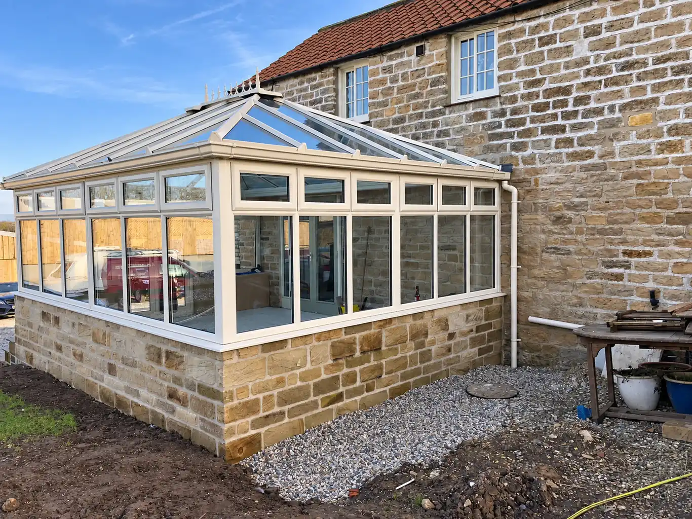 Stone based orangery against a farmhouse