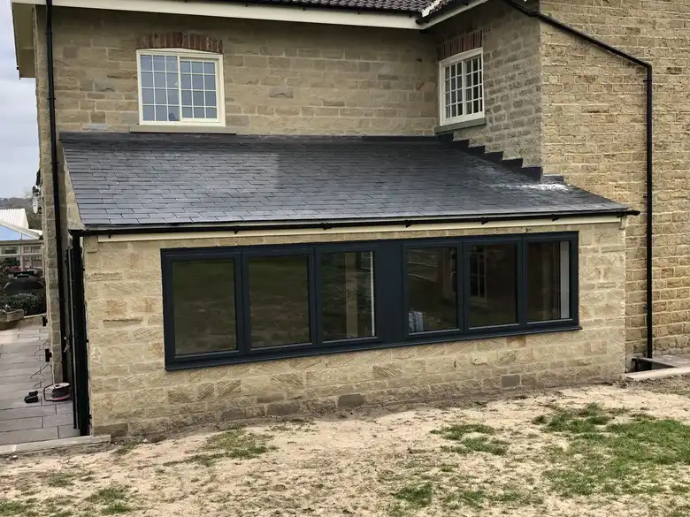 Stone single storey extension with aluminium glazing