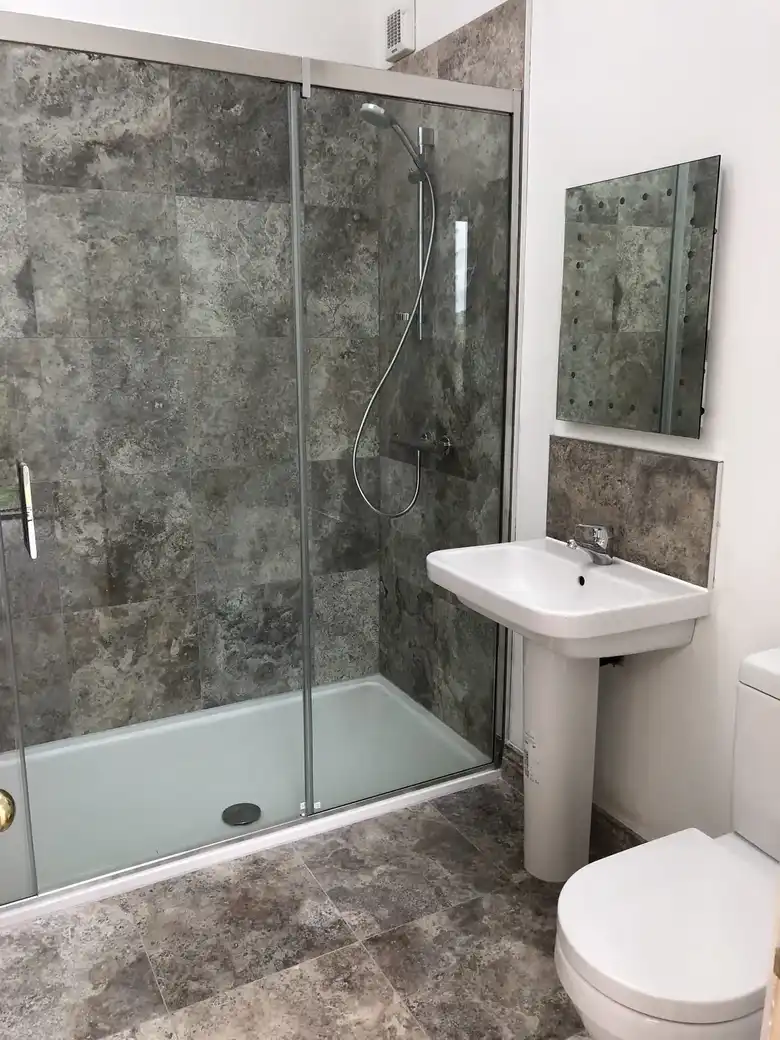 Stone tiled shower with glass screen