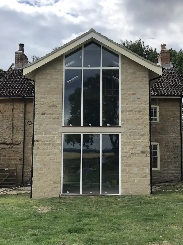 Tall glazed gable in stone