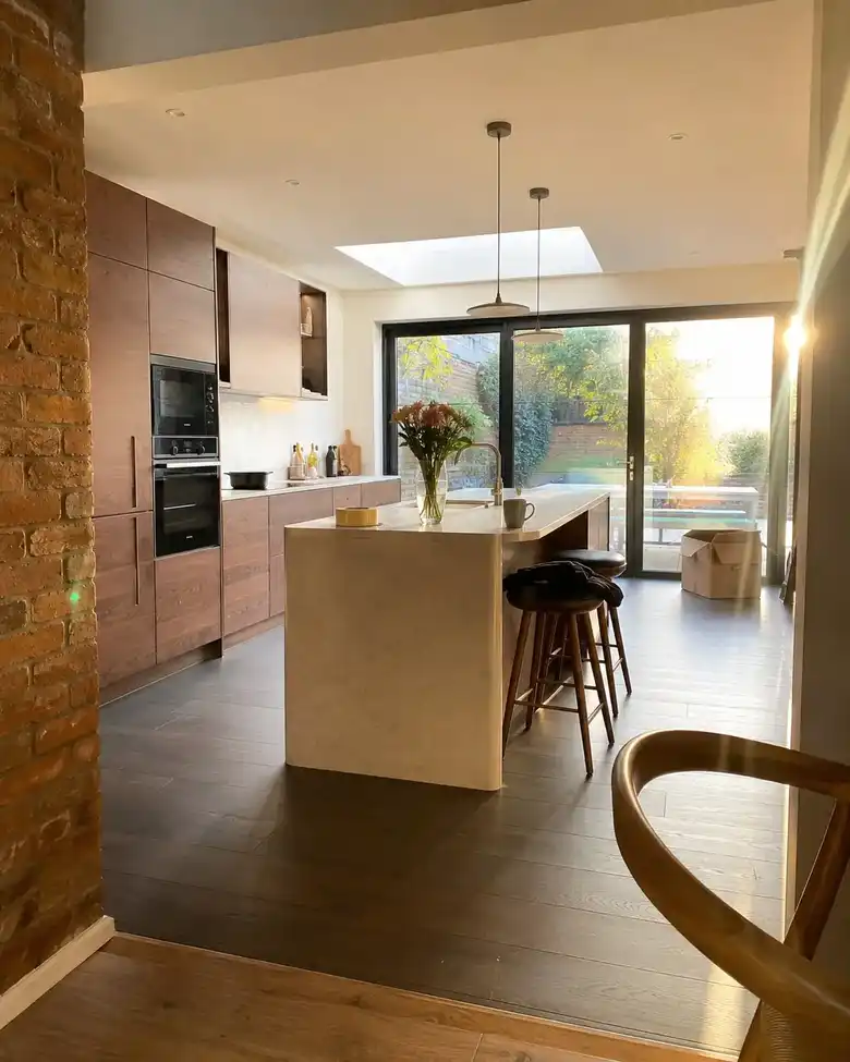 Walnut kitchen with a stone island and rooflight
